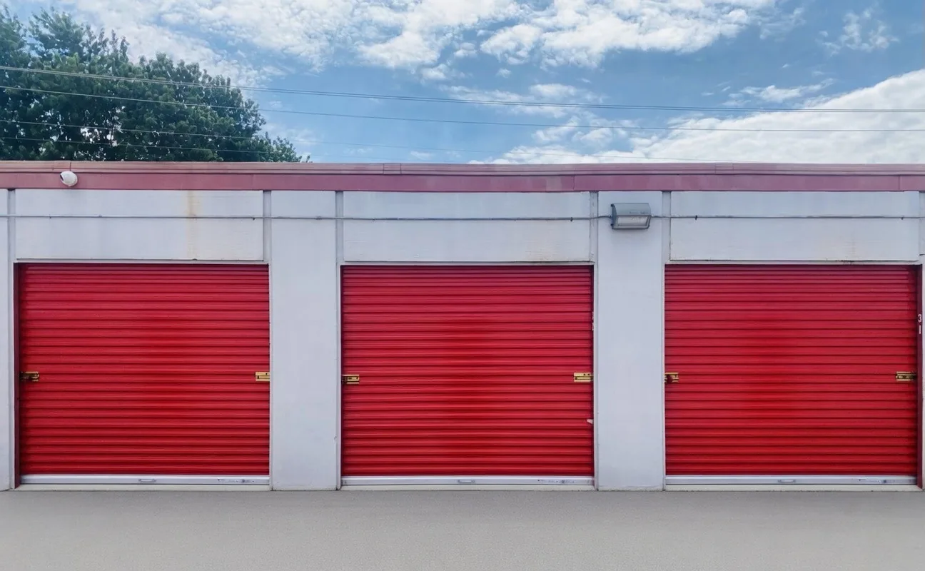 Red roll-up storage unit doors under blue sky